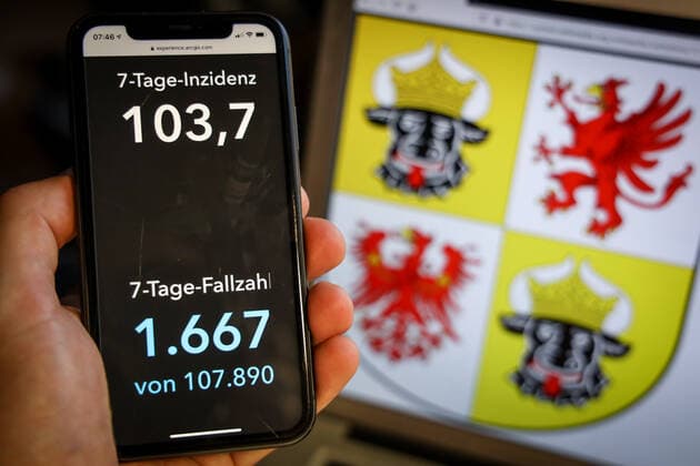 Coronavirus in Deutschland - Covid-19-Dashboard des Robert Koch-Institut DEU, Deutschland, Mecklenburg-Vorpommern, 28.03.2021: Die 7-Tage-Inzidenz für das Bundesland (Fälle letzte 7 Tage 100.000 EW) wird auf einem iPhone angezeigt, im Hintergrund das Landeswappen