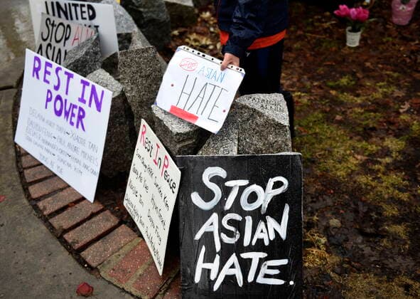 March 28, 2021, Ottawa, on, Canada: A child lays down a sign as people gather in the rain at the Ottawa Women s Monument in Minto Park for a vigil in memory of the victims of the Atlanta spa shootings and to rally against anti-Asian racism, in Ottawa, on Sunday, March 28, 2021. Ottawa Canada  - ZUMAc35_ 20210328_zaf_c35_064 Copyright: xJustinxTangx