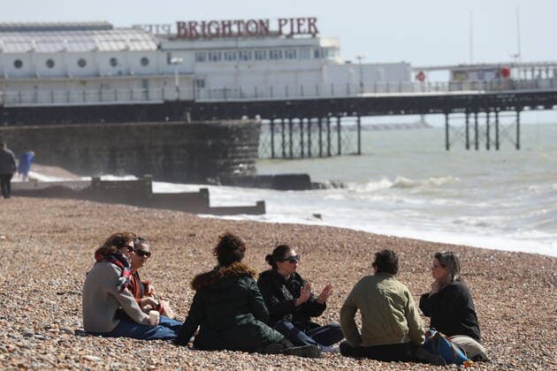 . 29 03 2021. Brighton, United Kingdom. A group of six friends enjoy the warm weather on Brighton beach on Happy Monday - the start of the latest Covid 19 lockdown easing .  xStephenxLockx xi-Imagesx IIM-22085-0026