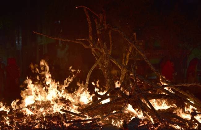 NOIDA, INDIA - MARCH 28: Hindu devotees offer prayers during Holika Dahan on March 28, 2021 in Noida, India. According to Hindu scriptures Holika Dahan, which is also known as Holika Deepak or Chhoti Holi celebrates victory of good over evil. As the legend of Bhakt Prahlad and his aunt demoness Holika depicts that anybody, howsoever strong, cannot harm a true devotee. And, those who dare torture a true devotee of god shall be reduced to ashes. (Photo by Sunil Ghosh Hindustan Times) Holika Dahal Festival Celebrated On The Eve Of Holi