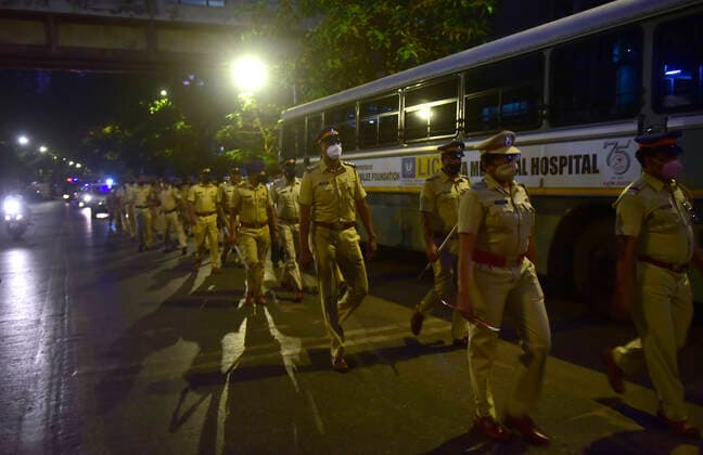 MUMBAI, INDIA - MARCH 28: Mumbai Police personnel held a flag march to raise awareness about night curfew between 8:00 pm to 7:00 am from Sunday, at Bhoiwada, Parel, on March 28, 2021 in Mumbai, India. (Photo by Anshuman Poyrekar Hindustan Times) Covid 19 Night Curfew In Mumbai Tourists Spot Wear Deserted Look