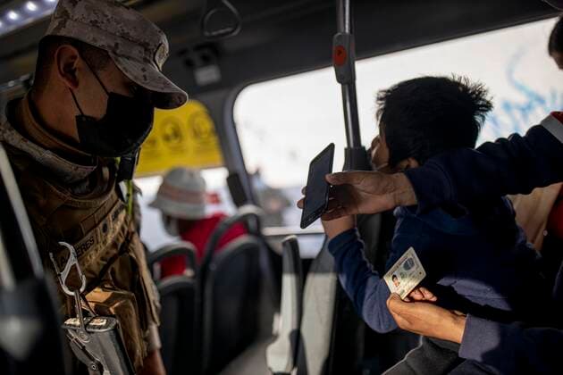 March 29, 2021, Santiago, Chile: A Bolivian migrant shows his health permit to a policeman during a public transport inspection..Sanitary cords and police controls during the first day of total quarantine in the central area of the country, after the abrupt increase in Covid-19 cases in the Metropolitan region, the country s health authorities decreed a total quarantine for the central area of the country. Although Chile leads the number of vaccinated population, the increase in positive cases puts the stability of the health system at risk again. Santiago Chile - ZUMAs197 20210329_zaa_s197_157 Copyright: xFelipexFigueroax
