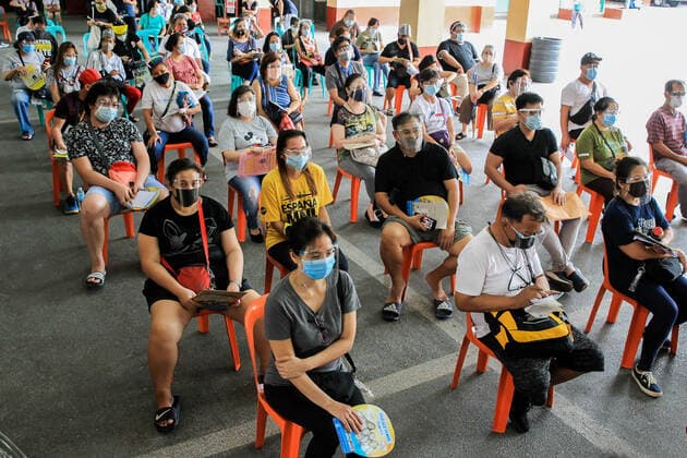 (210331) -- MANILA, March 31, 2021 -- Residents wearing protective masks wait to receive Sinovac vaccines at a vaccination site in Manila, the Philippines on March 31, 2021. The Philippines Department of Health (DOH) reported on Wednesday 6,128 new COVID-19 infections, bringing the total number of confirmed cases in the Southeast Asian country to 747,288. ) PHILIPPINES-MANILA-COVID-19-SINOVAC VACCINES RouellexUmali 