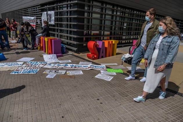 March 31, 2021, Barcelona, Catalonia, Spain: A couple leaving the hospital walks past placards laying on the ground, during the demonstration..Summoned by the platform against the obligation of sanitary masks in minors, El Tercer Grupo, some fifty people have gathered at the doors of the Sant Joan De Deu Children s Hospital to protest the call of the hospital to carry out tests of the covid 19 vaccine on minors. Barcelona Spain - ZUMAs197 20210331_zaa_s197_068 Copyright: xPacoxFreirex