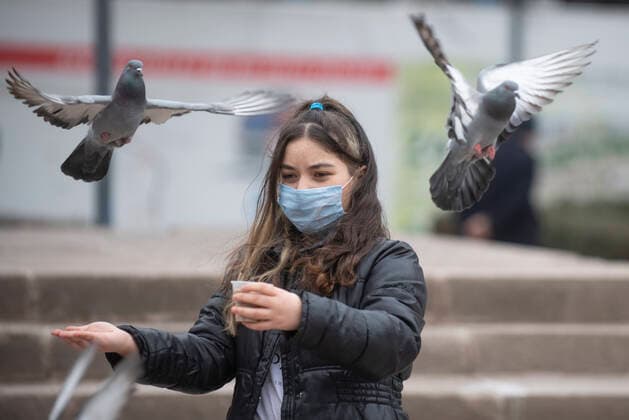 A woman wearing face mask feeds pigeons in Ankara, Turkey, on March 31, 2021. Turkey has confirmed 31,537 deaths and 3,317,182 positive cases of the coronavirus infection in the country. ( Copyright: AbdurrahmanxAntakyalix-xDepoxPho DSC_4067