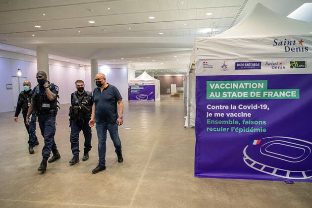 Coronavirus in Frankreich, neues Impfzentrum im Stade de France in Paris (210331) -- SAINT-DENIS (FRANCE), March 31, 2021 -- Policemen walk past a tent at a new COVID-19 vaccination center in Saint-Denis, France, on March 31, 2021. Starting from mid-April people over 60 in France will be able to get vaccinated, from May 15 the vaccination will be open to people aged between 50 and 60 and from mid-June the age limit will be lifted, said French President Emmanuel Macron on Wednesday. (Photo by Xinhua) FRANCE-SAINT-DENIS-VACCINATION CENTER AurelienxMorissard 