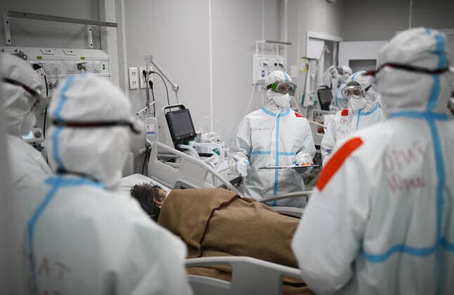 MOSCOW, RUSSIA - APRIL 1, 2021: Medical workers treat a patient at a temporary COVID-19 hospital at the Sokolniki Exhibition and Convention Center. The treatment facility has a reserve hospital and an observation center; its capacity is 550 beds, including 18 for intensive therapy patients. Sergei Bobylev TASS  TS0FB394