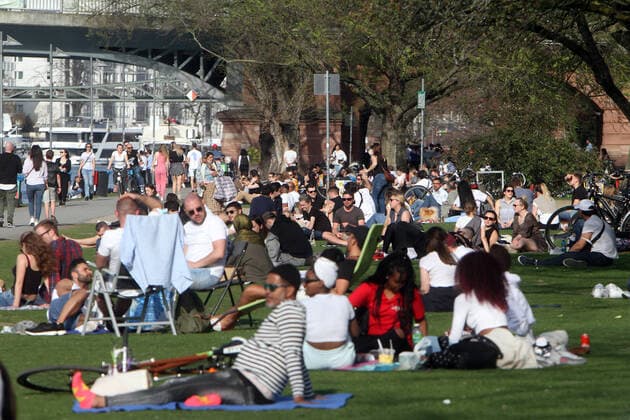 Hohe Temperaturen und strahlender Sonnenschein lockten in Frankfurt viele Menschen an das Mainufer und auf die Liegewiese. Die geltenden Abstandsregeln und Maskenpflicht wurden oftmals nicht eingehalten, Hessen, Deutschland