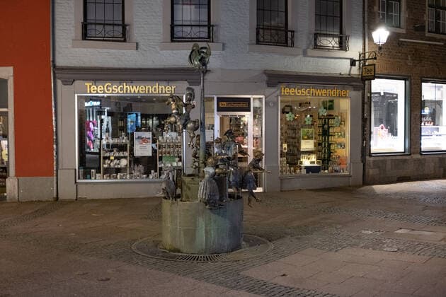 Like an abandoned city. Aachen on Easter vigil between 10 p.m. and 11 p.m. Only the dolls enliven the lonely doll fountain created in 1975 by the Aachen sculptor Bonifatius Stirnberg. In Aachen on April 3, 2021. GERMANY - AACHEN - EASTER Easter 2021 Covid Pandemic