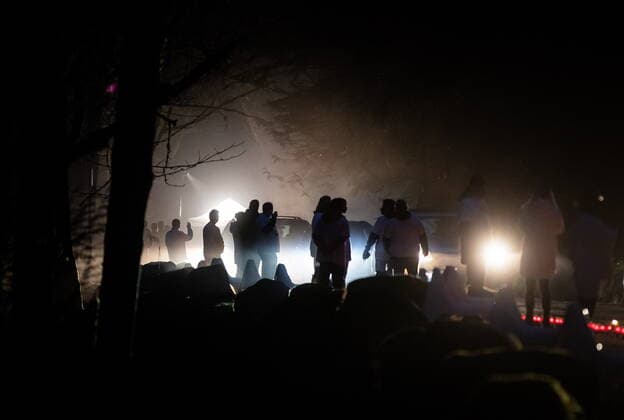 April 3, 2021, North Vancouver, BC, Canada: Volunteers holding candles lining the route are silhouetted as motorists drive past during a drive-thru candlelight vigil for the victims of last week s mass stabbing incident in and around the Lynn Valley Library, at Lynn Canyon Park in North Vancouver, B.C., on Saturday, April 3, 2021. North Vancouver Canada  - ZUMAc35_ 20210403_zaf_c35_099 Copyright: xDarrylxDyckx