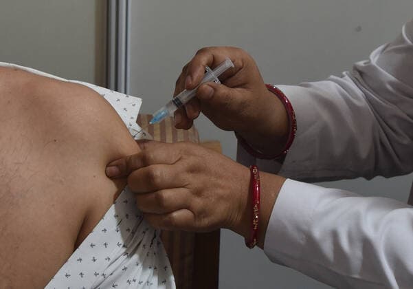 NEW DELHI, INDIA - APRIL 3: A medic administers a dose of COVID-19 vaccine to a man during a vaccination drive, at Maulana Azad Institute Of Dental Sciences, on April 3, 2021 in New Delhi, India. (Photo by Sonu Mehta Hindustan Times) India Begins Third Phase Of Vaccination Drive
