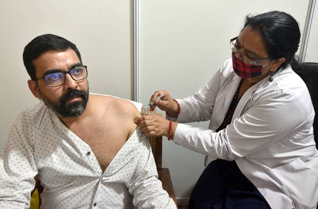 NEW DELHI, INDIA - APRIL 3: A medic administers a dose of COVID-19 vaccine to a man during a vaccination drive, at Maulana Azad Institute Of Dental Sciences, on April 3, 2021 in New Delhi, India. (Photo by Sonu Mehta Hindustan Times) India Begins Third Phase Of Vaccination Drive