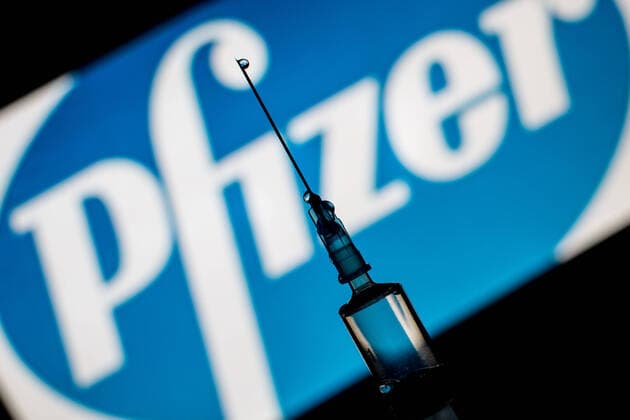Illustration with syringe and vaccine against Covid-19 ROME ITALY - APRIL 03: In this photographic illustration, a medical syringe seen displayed in front of the Pfizer Vaccine logo on April 03, 2021 in Rome, Italy. Roma Italy Copyright: AndreaxRonchini