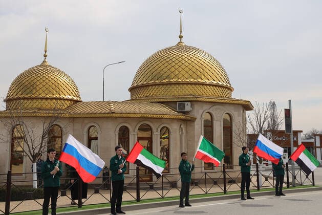 GROZNY, RUSSIA - APRIL 5, 2021: Men wave the flags of Russia, the UAE, and Chechnya during a ceremony to rename a street in honor of Sheikh Mohammed bin Zayed Al Nahyan, Crown Prince of Abu Dhabi. Taisiya Borshigova TASS  TS0FBA9E