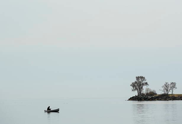 April 5, 2021, Toronto, on, Canada: A lone person fishes from a canoe on a calm Lake Ontario near Humber Bay during the COVID-19 pandemic in Toronto on Monday, April 5, 2021. Toronto Canada  - ZUMAc35_ 20210405_zaf_c35_034 Copyright: xNathanxDenettex