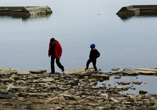 April 5, 2021, Toronto, on, Canada: People walk over looking on a calm Lake Ontario near Humber Bay during the COVID-19 pandemic in Toronto on Monday, April 5, 2021. Toronto Canada  - ZUMAc35_ 20210405_zaf_c35_036 Copyright: xNathanxDenettex