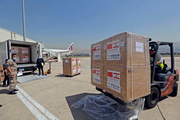 (210407) -- BEIRUT, April 7, 2021 -- Staff transport the Sinopharm vaccines donated by China at the Rafic Hariri International Airport in Beirut, Lebanon, April 6, 2021. Two batches of Sinopharm vaccines donated by China arrived in Lebanon on Tuesday. (Photo by Xinhua) LEBANON-BEIRUT-COVID-19-CHINESE VACCINES-ARRIVAL BilalxJawich 
