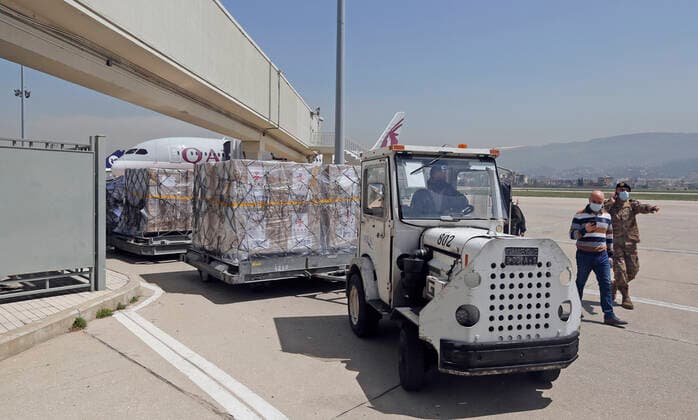 (210407) -- BEIRUT, April 7, 2021 -- Staff transport the Sinopharm vaccines donated by China at the Rafic Hariri International Airport in Beirut, Lebanon, April 6, 2021. Two batches of Sinopharm vaccines donated by China arrived in Lebanon on Tuesday. (Photo by Xinhua) LEBANON-BEIRUT-COVID-19-CHINESE VACCINES-ARRIVAL BilalxJawich 