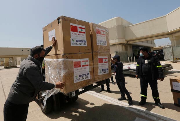 (210407) -- BEIRUT, April 7, 2021 -- Staff transport the Sinopharm vaccines donated by China at the Rafic Hariri International Airport in Beirut, Lebanon, April 6, 2021. Two batches of Sinopharm vaccines donated by China arrived in Lebanon on Tuesday. (Photo by Xinhua) LEBANON-BEIRUT-COVID-19-CHINESE VACCINES-ARRIVAL BilalxJawich 