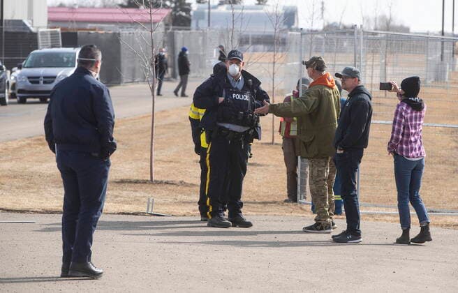 April 7, 2021, EDMONTON, ab, Canada: Supporters talk to police as a fence goes up around GraceLife Church near Edmonton on Wednesday April 7, 2021. The Alberta government has closed down and fenced off a church that has been charged with refusing to follow COVID-19 health rules. Alberta Health Services, in a statement, says GraceLife church will remain closed until it shows it will comply with public-health measures meant to contain the spread of the novel coronavirus. EDMONTON Canada  - ZUMAc35_ 20210407_zaf_c35_058 Copyright: xJasonxFransonx