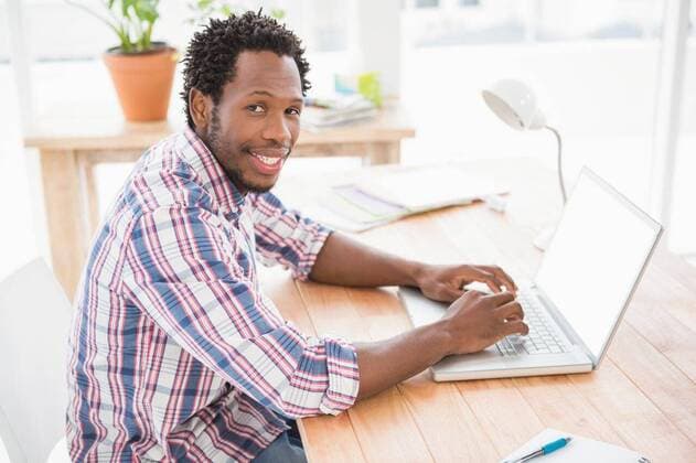 Smiling young businessman in front of the laptop Smiling young businessman in front of the laptop looking at the camera in the office, model released, Cape Town, South Africa, 30.04.2015, 550508.jpg, creative, business, casual, cool, design, designer, studio, office, job, profession, professional, career, occupation, brainstorm, brainstorming, hip, briefing, style, design professional, brown eyes, dark eyes, short hair, brunette, brown hair, plants, laptop, typing, happy, smiling, cheerful 20s, Young Adult, Man, Male, Mixed-Race, 20-24 Years, Young Men, Mixed-Race Person