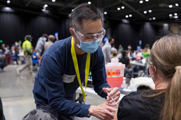 April 7, 2021, Seattle, Washington, USA: Volunteer TODD YOSHINO administers a dose of the PfizerÃ¢â‚¬BioNTech COVID-19 vaccine to a patient at the Lumen Field Event Center in Seattle on Wednesday, April 7, 2021. The City of Seattle administered a record 7,615 doses of vaccine at the site on Wednesday. Seattle USA - ZUMAg235 20210407_zap_g235_006 Copyright: xPaulxChristianxGordonx
