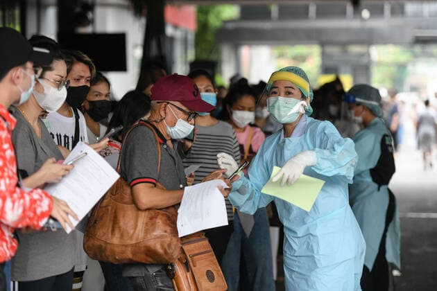 April 8, 2021, Bangkok, Thailand: A health worker wearing a personal protective equipment suite (PPE) assisting a woman in a queue for verification of his documents during a swab test drive outside a nightclub in Bangkok..The Ministry of Public Health is set to recommend the closure of night entertainment spots in high-risk areas of Bangkok, in order to deal with the fast-spreading UK variant of the coronavirus. The UK variant is believed to have played a significant role in the spread of the latest cluster of infections detected at entertainment venues across the capital. Bangkok Thailand - ZUMAs197 20210408_zaa_s197_056 Copyright: xAmpholxThongmueangluangx