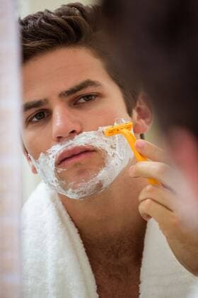 Reflection of young man shaving Young man shaving in front of bathroom mirror, model released, , property released, Cape Town, South Africa, 08.12.2015, 711215.jpg, home, Ã‚ house, Ã‚ household, Ã‚ homey, Ã‚ apartment, domicile, Ã‚ abode, bathroom, domestic life, smart, attractive, beard, looking, towel, shaving, reflection, mirror, razor, shaver, skincare, bodycare, grooming, masculinity, daily routine, hygiene Indoors,Front view,Head and shoulders