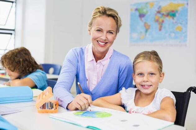 IMAGO Kreativ: Bildung, Kunsterziehung Teacher helping schoolgirl with her homework in classroom Teacher helping schoolgirl with her homework in classroom at school, model released, , property released, Cape Town, South Africa, 05.03.2016, 753635.jpg, classroom, class, student, primary, school, schoolgirl, schoolchild, kids, teacher, casual clothing, blonde hair, desk, wheelchair, handicapped, disabled, disability, sitting, smiling, cheerful, happy, drawing, assisting, drawing book, felt pen, pencil box, learn, learning, studying, teaching, study, development, elementary, elementary school, education, back to school, childhood, innocence, knowledge, academic, lifestyle, art, creativity, leisure, guidance, together Indoors,Looking at camera