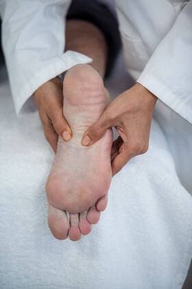 Senior man receiving foot massage from physiotherapist Senior man receiving foot massage from physiotherapist in clinic, model released, Cape Town, South Africa, 01.06.2016, 804490.jpg, medical, clinic, hospital, practitioner, doctor, specialist, physio, therapist, physical therapist, physiotherapist, physiotherapy, osteopath, orthopedic, patient, old man, aged, senior, lying, leg, foot, sole, hand, part of, massage, massaging, foot massage, assisting, assistance, pressing, acupressure, reflexology, illness, sick, pain, relief, relaxation, treatment, healing, wellness, cure, recovery, health service, healthcare, bodycare, healthcare and medicine, expertise, profession, professional Indoors