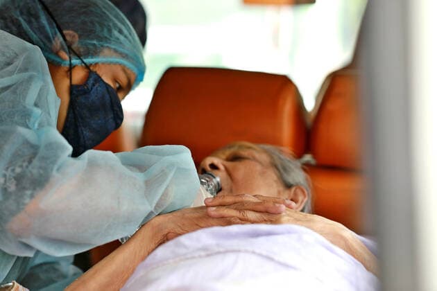 April 9, 2021, Dhaka, Dhaka, Bangladesh: April, 09,2021 A relative of a woman who has infected by the COVID-19 and she wearing a protective suit help to drink water to elderly woman in an ambulance, Dhaka, Bangladesh Dhaka Bangladesh - ZUMAr338 20210409_zip_r338_019 Copyright: xHarun-Or-Rashidx