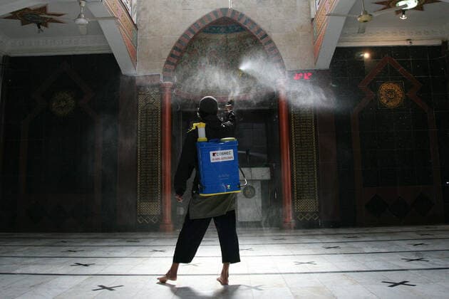 Indonesia: Mosque sanitization to welcome the holy month of Ramadan A resident sprays disinfectant liquid at one of the mosques in the Pondok Gede residential area, Bekasi, West Java. Spraying disinfectant liquid and cleaning the mosque in order to welcome the holy month of Ramadan so that the mosque is in a clean and sterile condition from the spread of the Corona virus (Covid-19) when it is used by residents during worship and activities in the mosque area. Bekasi West Java Indonesia Copyright: KuncoroxWidyoxRumpoko