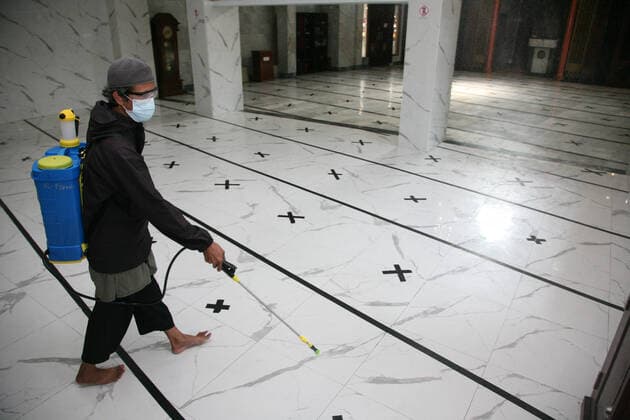 Indonesia: Mosque sanitization to welcome the holy month of Ramadan A resident sprays disinfectant liquid at one of the mosques in the Pondok Gede residential area, Bekasi, West Java. Spraying disinfectant liquid and cleaning the mosque in order to welcome the holy month of Ramadan so that the mosque is in a clean and sterile condition from the spread of the Corona virus (Covid-19) when it is used by residents during worship and activities in the mosque area. Bekasi West Java Indonesia Copyright: KuncoroxWidyoxRumpoko