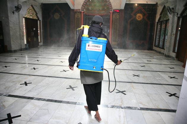 Indonesia: Mosque sanitization to welcome the holy month of Ramadan A resident sprays disinfectant liquid at one of the mosques in the Pondok Gede residential area, Bekasi, West Java. Spraying disinfectant liquid and cleaning the mosque in order to welcome the holy month of Ramadan so that the mosque is in a clean and sterile condition from the spread of the Corona virus (Covid-19) when it is used by residents during worship and activities in the mosque area. Bekasi West Java Indonesia Copyright: KuncoroxWidyoxRumpoko