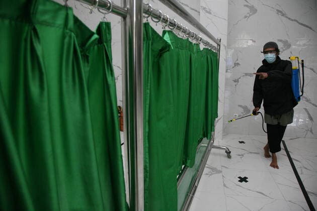 Indonesia: Mosque sanitization to welcome the holy month of Ramadan A resident sprays disinfectant liquid at one of the mosques in the Pondok Gede residential area, Bekasi, West Java. Spraying disinfectant liquid and cleaning the mosque in order to welcome the holy month of Ramadan so that the mosque is in a clean and sterile condition from the spread of the Corona virus (Covid-19) when it is used by residents during worship and activities in the mosque area. Bekasi West Java Indonesia Copyright: KuncoroxWidyoxRumpoko