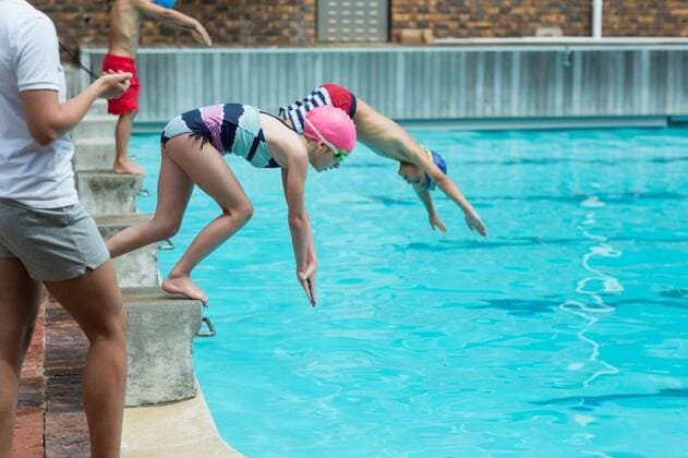 IMAGO Creative: Lokalhelden - Jugendsportbildung Female instructor monitoring time of children diving in pool Mid section of female instructor monitoring time of children diving in pool, model released, , property released, Cape Town, South Africa, 12.12.2016, 949303.jpg, instructor, monitoring, time, poolside, timing, standing, swimming pool, pool, water, sport, leisure, gym, leisure center, water sport, swimming, leisure activity, recreational pursuit, healthy lifestyle, athletic, fit, fitness, healthy, swim, sportswear, trainer, coach, stopwatch, swimwear, swimmer, cute, childhood, learning Outdoors,Side view,Day