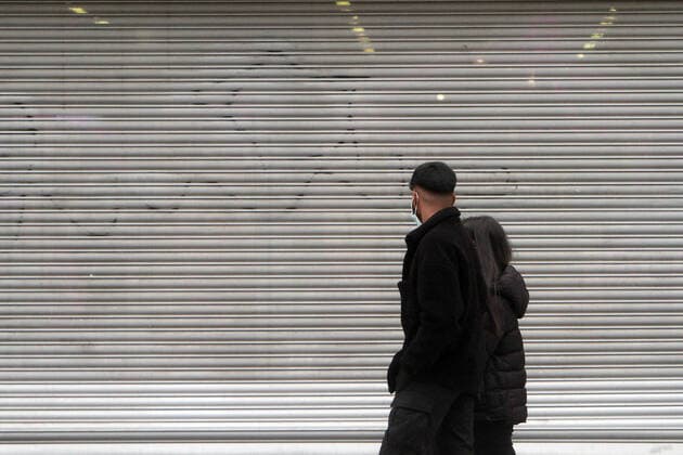 Passanten gehen an einem mit Rolltor verschlossenen Geschäft in der Einkaufsstraße Fußgängerzone Zeil in der Innenstadt von Frankfurt, Hessen, Deutschland