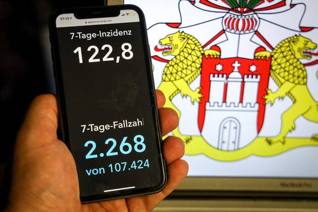 Coronavirus in Deutschland - Covid-19-Dashboard des Robert Koch-Institut DEU, Deutschland, Hamburg, 11.04.2021: Die 7-Tage-Inzidenz für das Bundesland (Fälle letzte 7 Tage 100.000 EW) wird auf einem iPhone angezeigt, im Hintergrund das Landeswappen