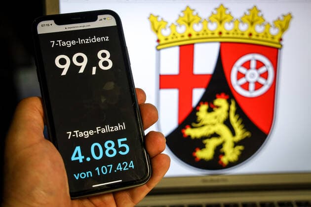 Coronavirus in Deutschland - Covid-19-Dashboard des Robert Koch-Institut DEU, Deutschland, Rheinland-Pfalz, 11.04.2021: Die 7-Tage-Inzidenz für das Bundesland (Fälle letzte 7 Tage 100.000 EW) wird auf einem iPhone angezeigt, im Hintergrund das Landeswappen