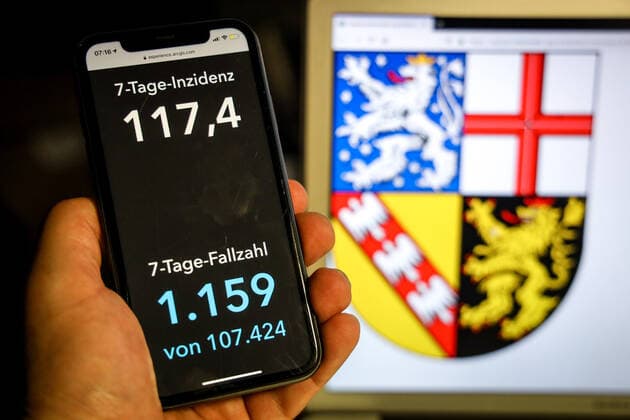 Coronavirus in Deutschland - Covid-19-Dashboard des Robert Koch-Institut DEU, Deutschland, Saarland, 11.04.2021: Die 7-Tage-Inzidenz für das Bundesland (Fälle letzte 7 Tage 100.000 EW) wird auf einem iPhone angezeigt, im Hintergrund das Landeswappen