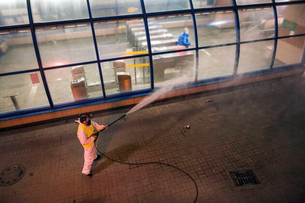 April 11, 2021, Warsaw, Poland: A cleaning service worker is seen disinfecting the street next to the entrance to the metro station..At night, the municipal cleaning services disinfect the most important and most frequently used communication routes in the center of Warsaw. Disinfection was carried out with highly ozonated water - it is an innovative Polish method..Disinfection of Warsaw was performed due to the covid 19 pandemic, the third wave of the virus is currently raging in Poland, there is a shortage of places in hospitals and the average daily number of new cases is around 30,000, while deaths are over 600. Warsaw Poland - ZUMAs197 20210411_zaa_s197_020 Copyright: xAttilaxHusejnowx