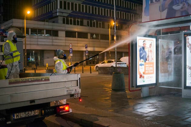 April 11, 2021, Warsaw, Poland: Cleaning service workers are seen disinfecting a bus stop in Warsaw s center..At night, the municipal cleaning services disinfect the most important and most frequently used communication routes in the center of Warsaw. Disinfection was carried out with highly ozonated water - it is an innovative Polish method..Disinfection of Warsaw was performed due to the covid 19 pandemic, the third wave of the virus is currently raging in Poland, there is a shortage of places in hospitals and the average daily number of new cases is around 30,000, while deaths are over 600. Warsaw Poland - ZUMAs197 20210411_zaa_s197_021 Copyright: xAttilaxHusejnowx