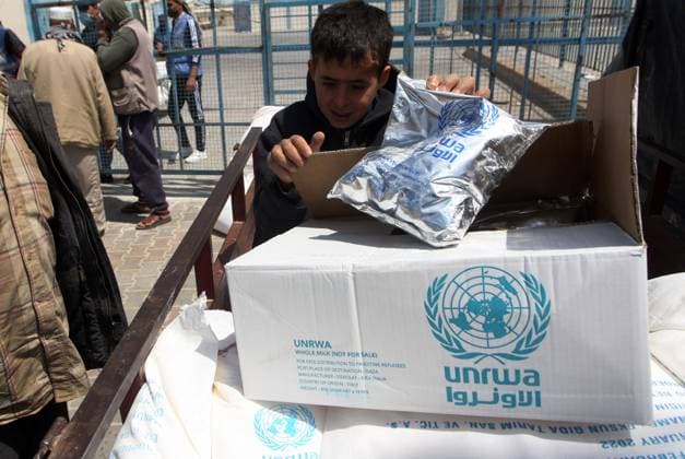 Palestinians receive aid distributed by United Nations Relief and Works Agency (UNRWA) at the Rafah refugee camp in the southern Gaza Strip on Sunday, April 11, 2021. The United States said it was restoring assistance to the Palestinians, and would contribute $150 million to the UN agency, plus $75 million in economic and development assistance for the West Bank and Gaza as well as $10 million for peacebuilding efforts.  GAZ202104110522 IsmaelxMohamad