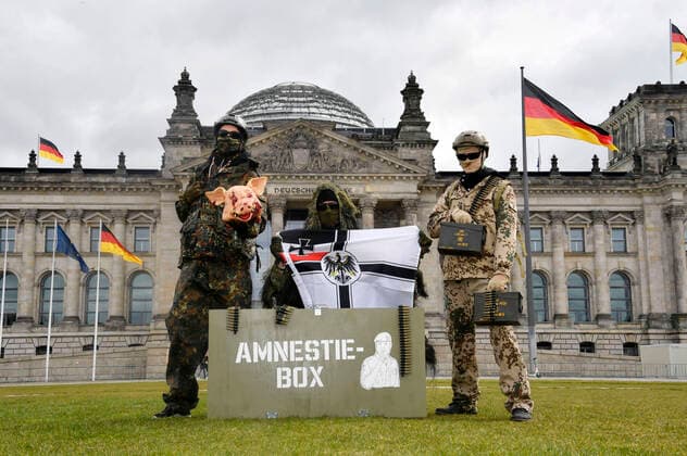 Bilder des Jahres 2021, News 04 April News Themen der Woche KW15 News Bilder des Tages Protestaktion zur Sondersitzung des Verteidigungsausschusses des Bundestags zu den Vorfällen bei den Kommando Spezialkräften (KSK) der Bundeswehr vor dem Reichstagsgebäude. Bei der Aktion führen drei als KSK-Soldaten in voller Tarnmontur gekleidete Aktivisten vor der Kulisse des Bundestagsgebäudes die letzten Skandale der Bundeswehr-Einheit vor: Einer hält einen (künstlichen) blutverschmierten Schweinekopf in Händen, ein anderer zeigt rechtsextreme Symbolik und der dritte trägt Munitionskisten und Munition. Damit sollen die skandalträchtigen Partys einiger KSK-Soldaten (bei denen reale Schweineköpfe verwendet wurden), die rechtsextremen Vorfälle in der Einheit sowie den Munitionsklau symbolisiert werden. Weiterhin wird ein Tra Foto:xF.xKernx xFuturexImage