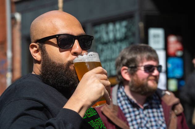 Friends enjoy their first pints from a bar following the relaxing of lockdown restrictions on Thomas Street in the sunshine in central Manchester on 12 April 2021. Customers have returned to the High Street on Monday as non-essential retailers in England and Wales reopened after more than three months of lockdown restrictions due to the Covid-19 pandemic. Manchester Greater Manchester England City Centre  Copyright: xMattxWilkinsonx