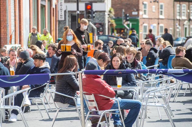People drinking at outside tables at a bar following the relaxing of lockdown restrictions, on Stevenson Square in the sunshine, in central Manchester on 12 April 2021. Customers have returned to the High Street on Monday as non-essential retailers in England and Wales reopened after more than three months of lockdown restrictions due to the Covid-19 pandemic. Manchester Greater Manchester England City Centre  Copyright: xMattxWilkinsonx