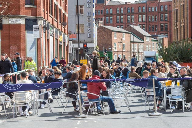 People drinking at outside tables at a bar following the relaxing of lockdown restrictions, on Stevenson Square in the sunshine, in central Manchester on 12 April 2021. Customers have returned to the High Street on Monday as non-essential retailers in England and Wales reopened after more than three months of lockdown restrictions due to the Covid-19 pandemic. Manchester Greater Manchester England City Centre  Copyright: xMattxWilkinsonx