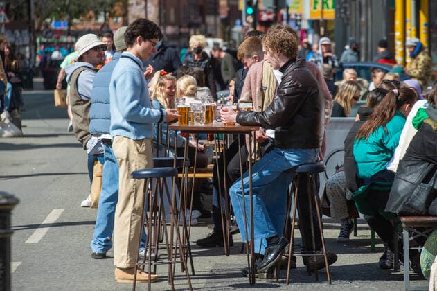 People drinking at outside tables at a bar following the relaxing of lockdown restrictions, on Stevenson Square in the sunshine, in central Manchester on 12 April 2021. Customers have returned to the High Street on Monday as non-essential retailers in England and Wales reopened after more than three months of lockdown restrictions due to the Covid-19 pandemic. Manchester Greater Manchester England City Centre  Copyright: xMattxWilkinsonx