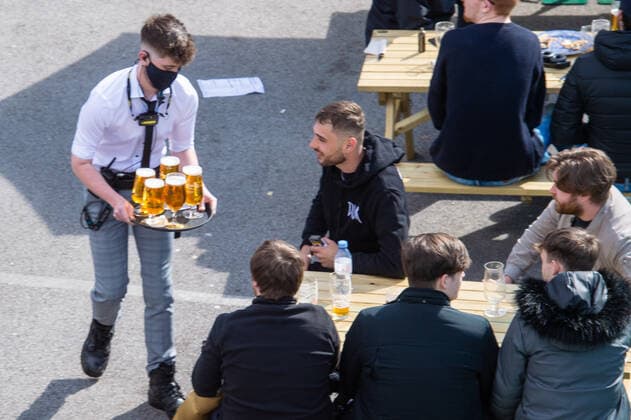 A waiter serves customers at the JD Wetherspoon Gateway pub in East Didsbury, south Manchester on 12 April 2021. Customers have returned to the High Street on Monday as non-essential retailers in England and Wales reopened after more than three months of lockdown restrictions due to the Covid-19 pandemic. Manchester Greater Manchester England City centre  Copyright: xMattxWilkinsonx