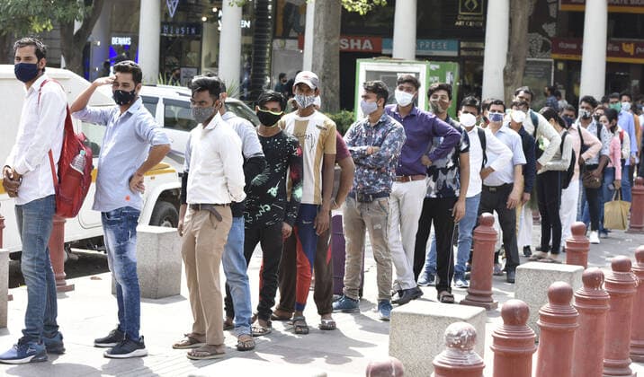 NEW DELHI, INDIA - APRIL 12: Commuters wait in a long queue outside Rajiv Chowk Metro Station after DMRC allowed travelers to enter in small groups as a preventive measure against the Covid-19 coronavirus, at Connaught Place, on April 12, 2021 in New Delhi, India. (Photo by Sonu Mehta Hindustan Times) Daily Life Amid Rise In Coronavirus Cases In India